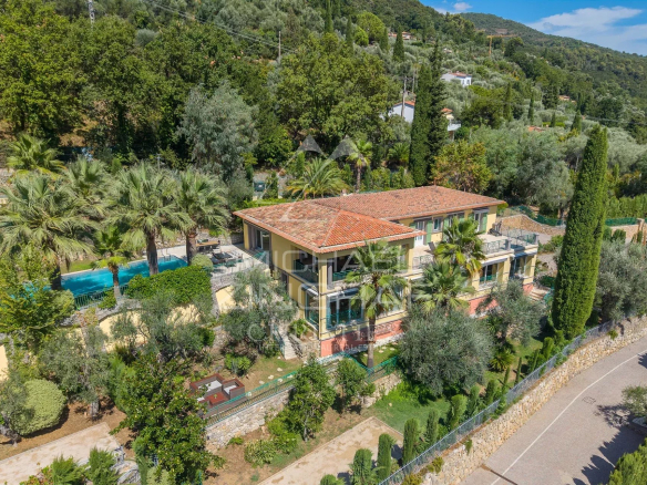 Villa rénovée avec piscine et jardin à Grasse, vue sur collines.