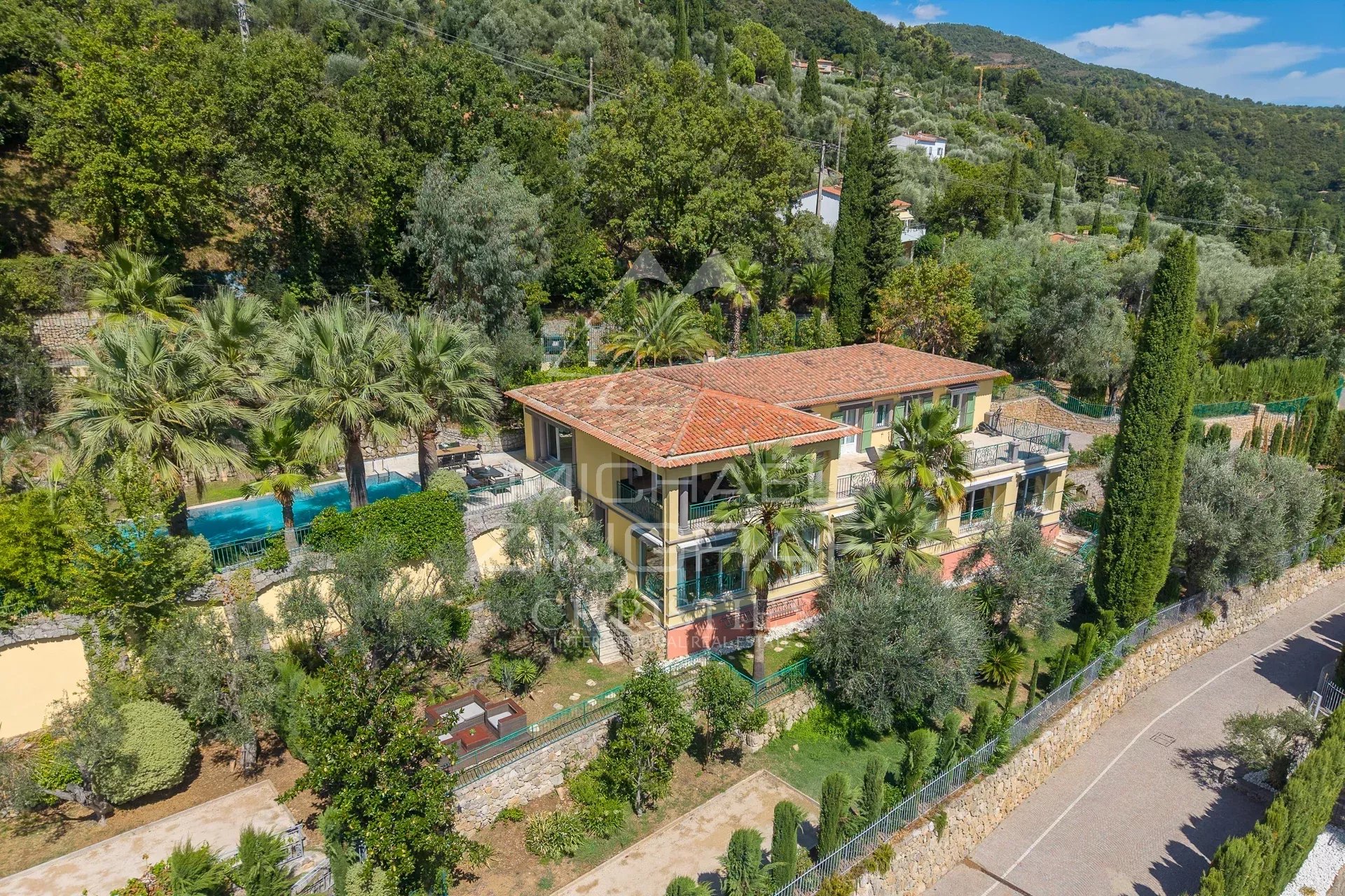 Villa rénovée avec piscine et jardin à Grasse, vue sur collines.