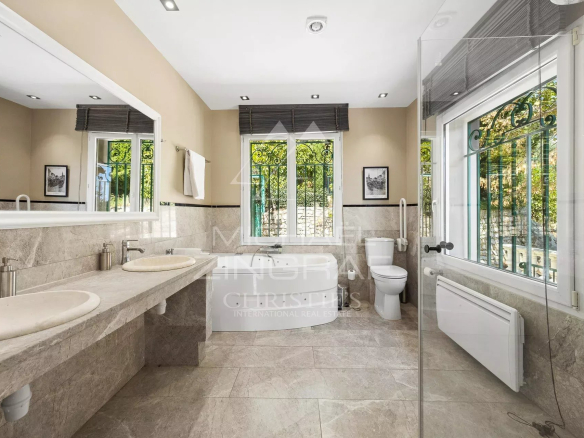 Salle de bain moderne avec baignoire et double vasque dans une villa à Grasse.