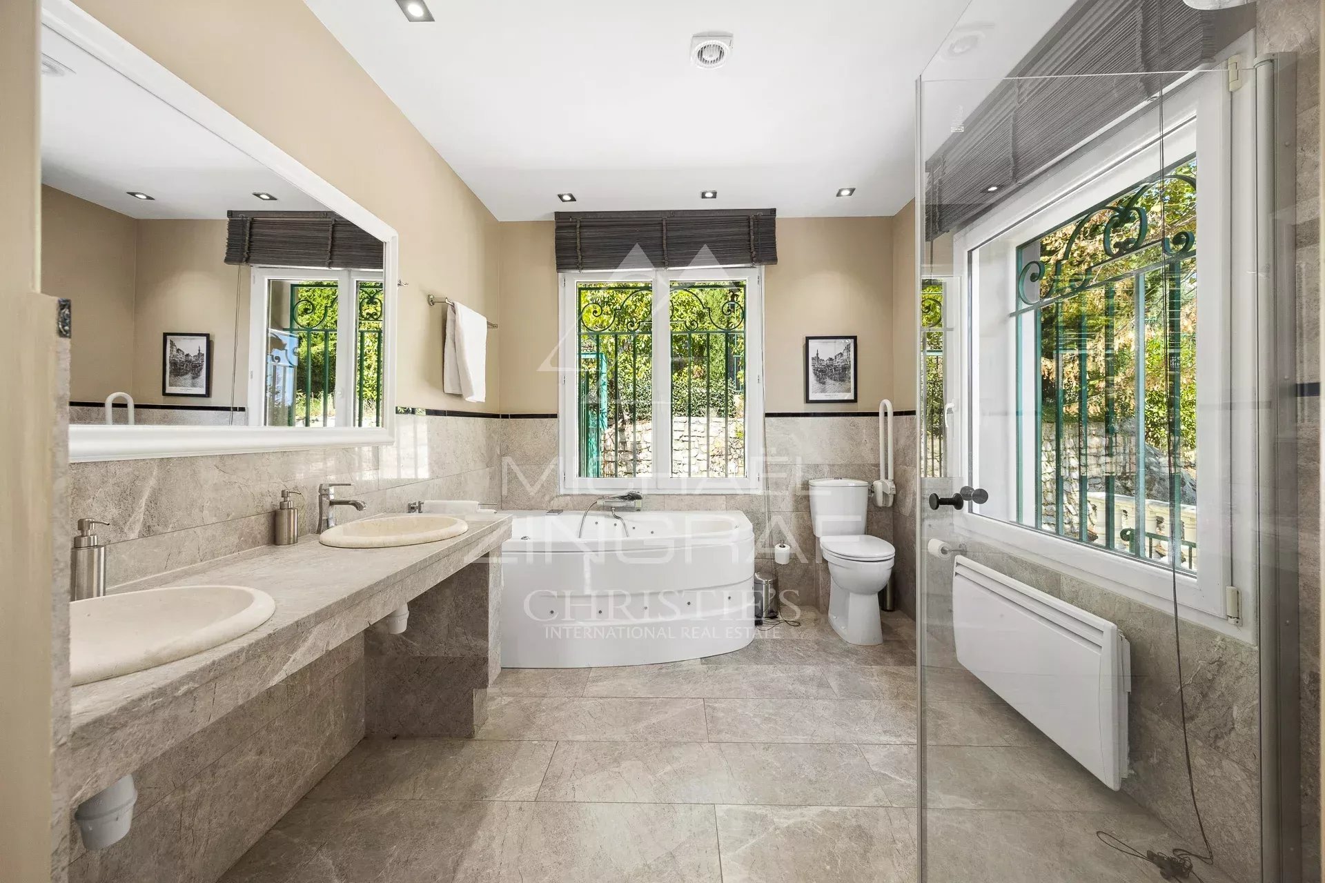 Salle de bain moderne avec baignoire et double vasque dans une villa à Grasse.