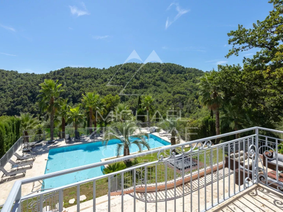 Vue dégagée sur la piscine et les collines depuis une villa à Grasse.