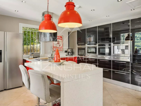 Cuisine moderne avec îlot central et appareils électroménagers intégrés dans une villa à Grasse.