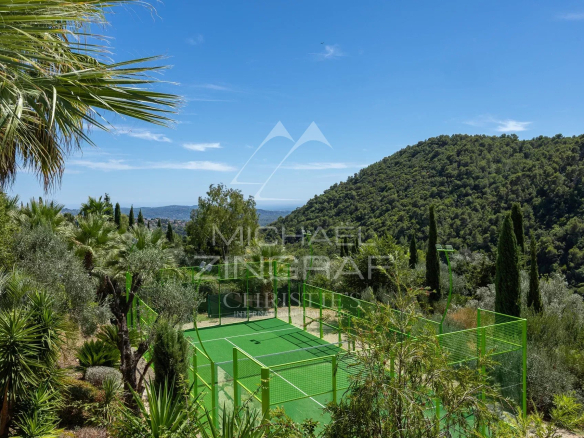 Vue dégagée sur un jardin méditerranéen avec un court de tennis à Grasse.
