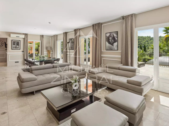 Intérieur d'une bastide contemporaine à Grasse avec salon spacieux et vue sur la nature.