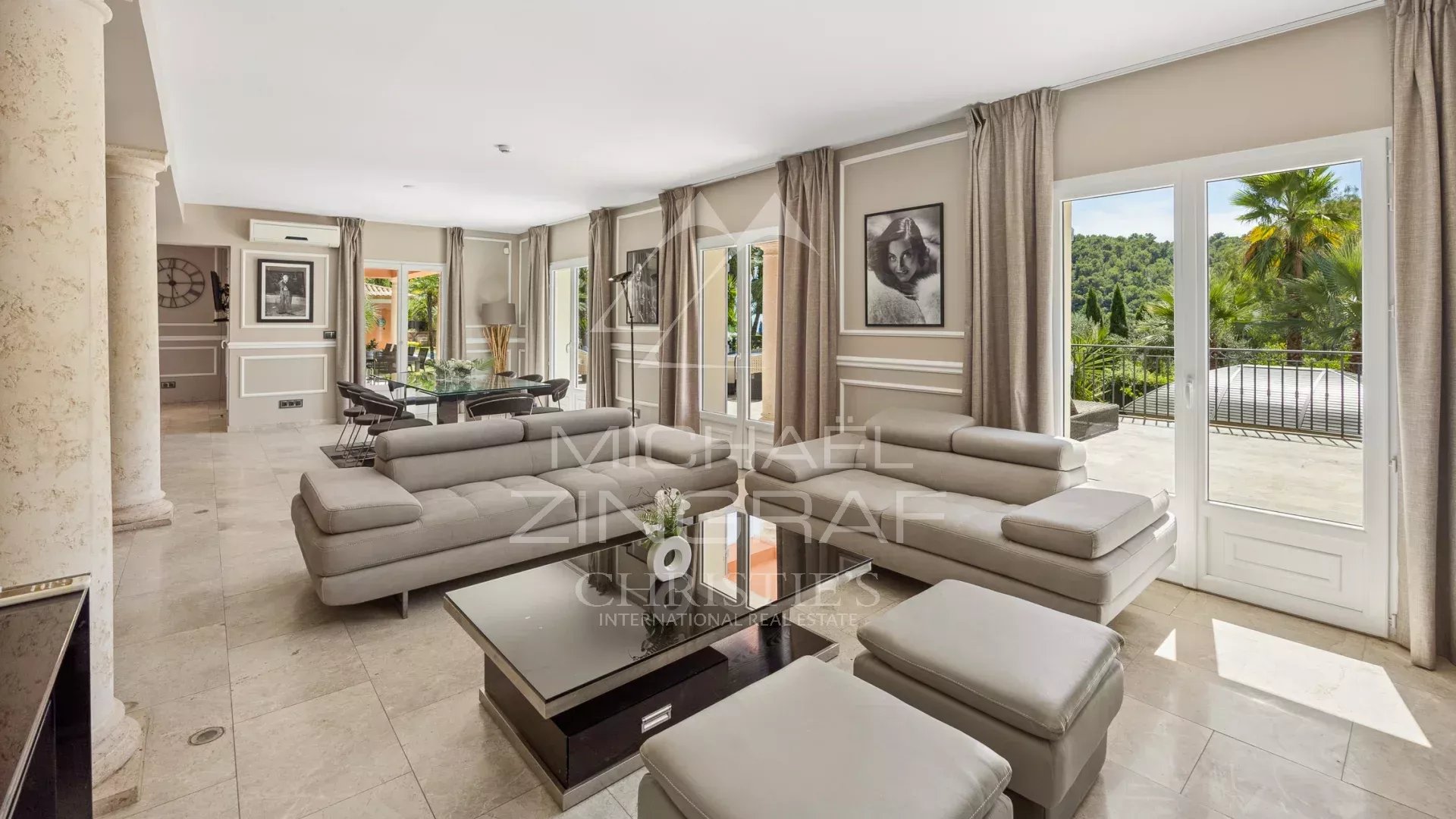 Intérieur d'une bastide contemporaine à Grasse avec salon spacieux et vue sur la nature.