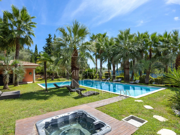 Bastide contemporaine avec piscine et jardin à Grasse, entourée de palmiers.