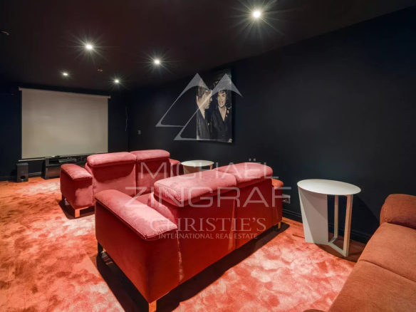 Salle de cinéma avec canapés rouges dans une bastide contemporaine à Grasse.