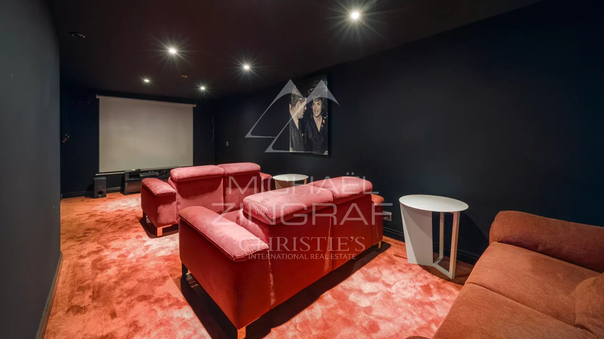 Salle de cinéma avec canapés rouges dans une bastide contemporaine à Grasse.