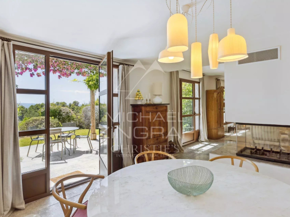 Interior of a Mediterranean villa with a view, dining table and fireplace