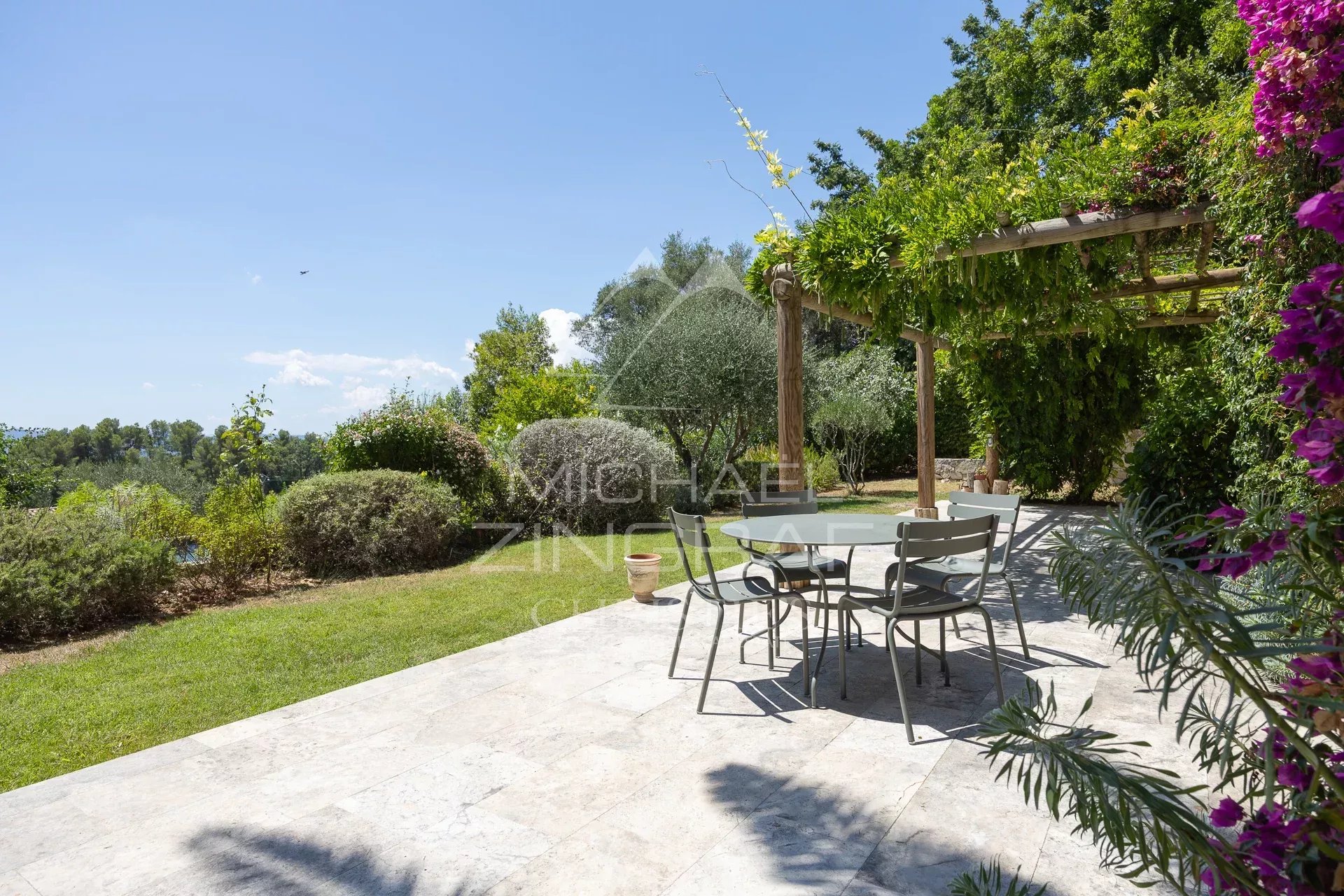 Terrace of a Mediterranean villa with garden furniture and lush vegetation in Châteauneuf-Grasse.