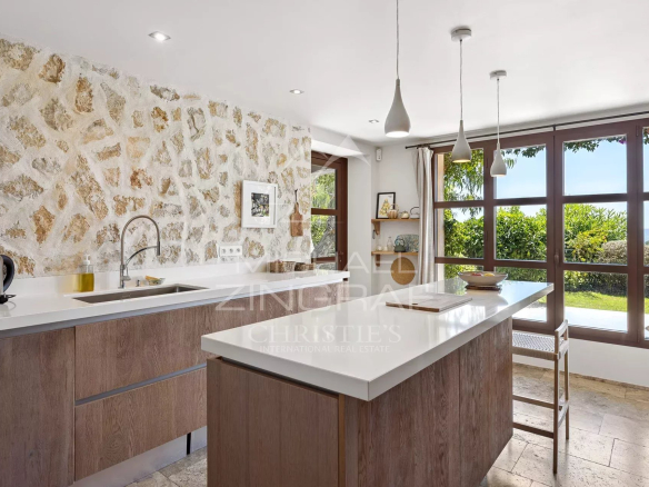 Modern kitchen with stone walls and windows offering a view of the outside.
