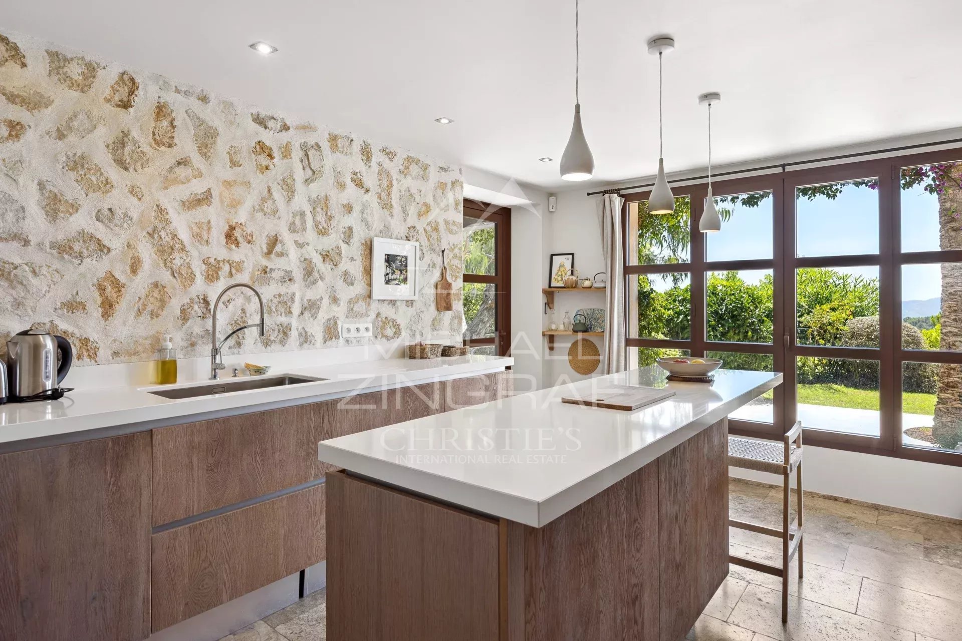 Modern kitchen with stone walls and windows offering a view of the outside.
