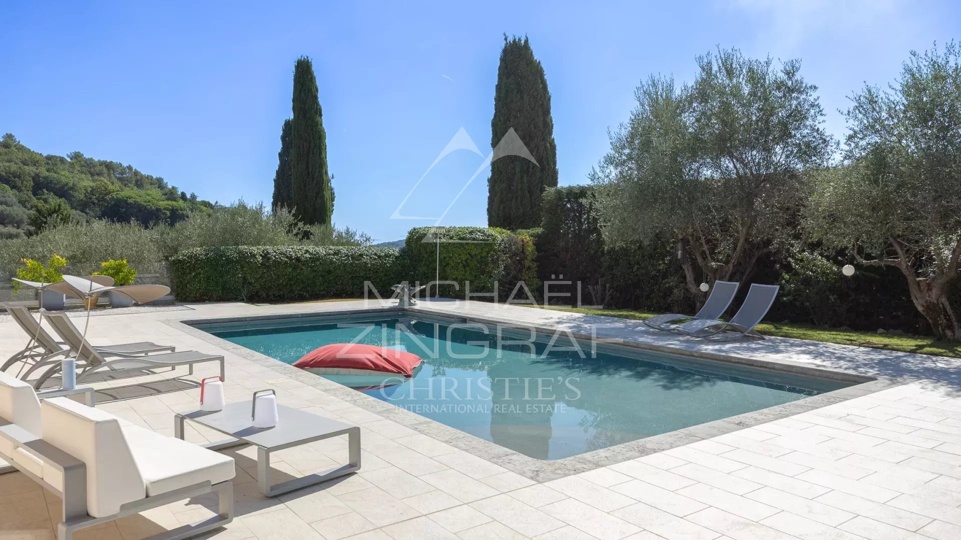 Villa moderne avec piscine à Grasse, entourée d'oliviers et d'un jardin paysager.