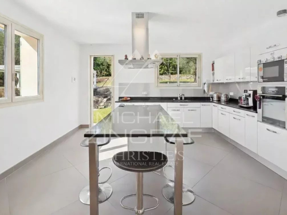 Cuisine moderne et lumineuse d'une villa à Grasse avec îlot central et équipements récents.