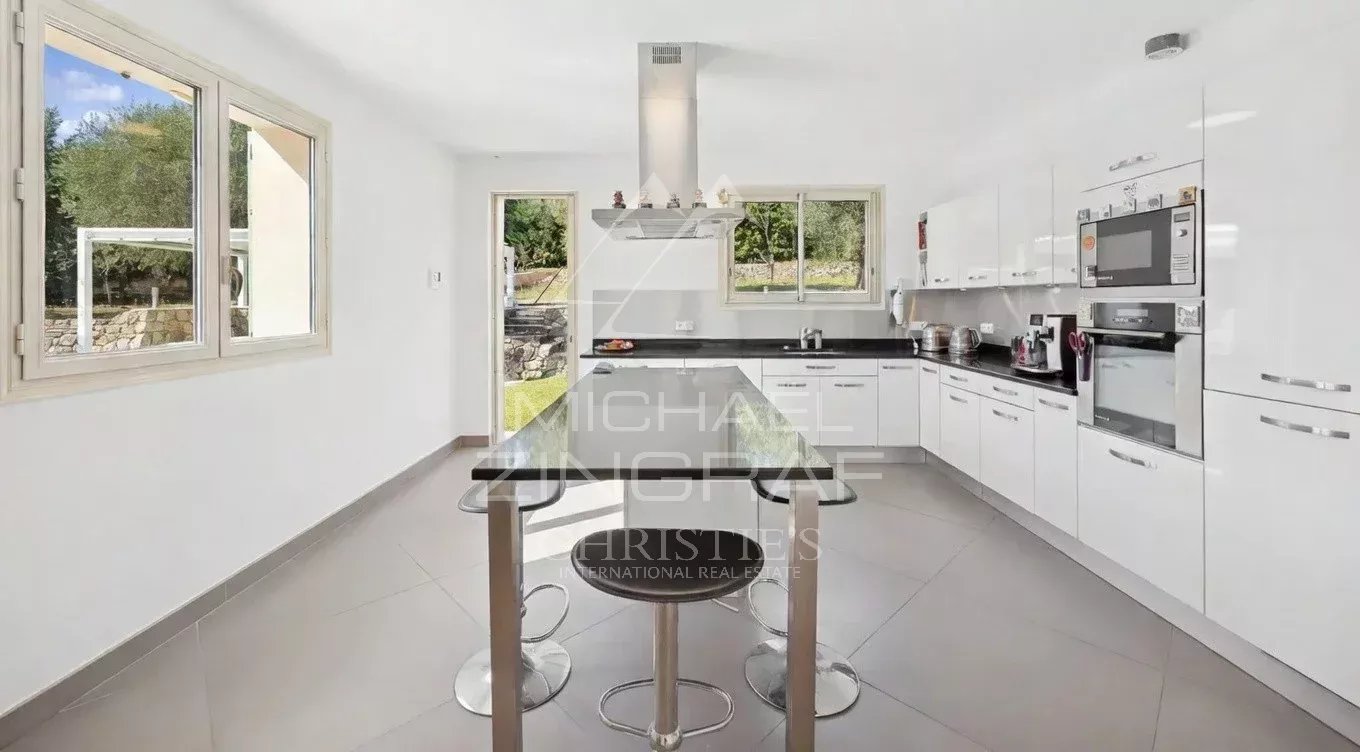 Cuisine moderne et lumineuse d'une villa à Grasse avec îlot central et équipements récents.