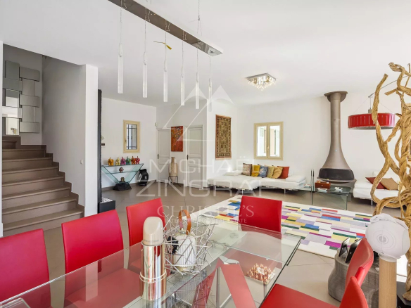Intérieur d'une villa moderne avec salon lumineux et salle à manger, meubles contemporains.