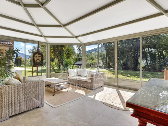 Bright veranda of a stone property, surrounded by nature in Le Bar-sur-Loup.