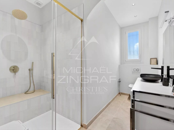 Modern bathroom with shower and sink in a renovated property.