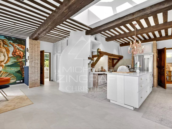 Interior of a renovated property with exposed beams and a modern kitchen.