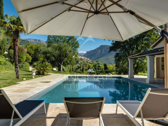 View of the pool and garden of a renovated property in Le Bar-sur-Loup, surrounded by nature.