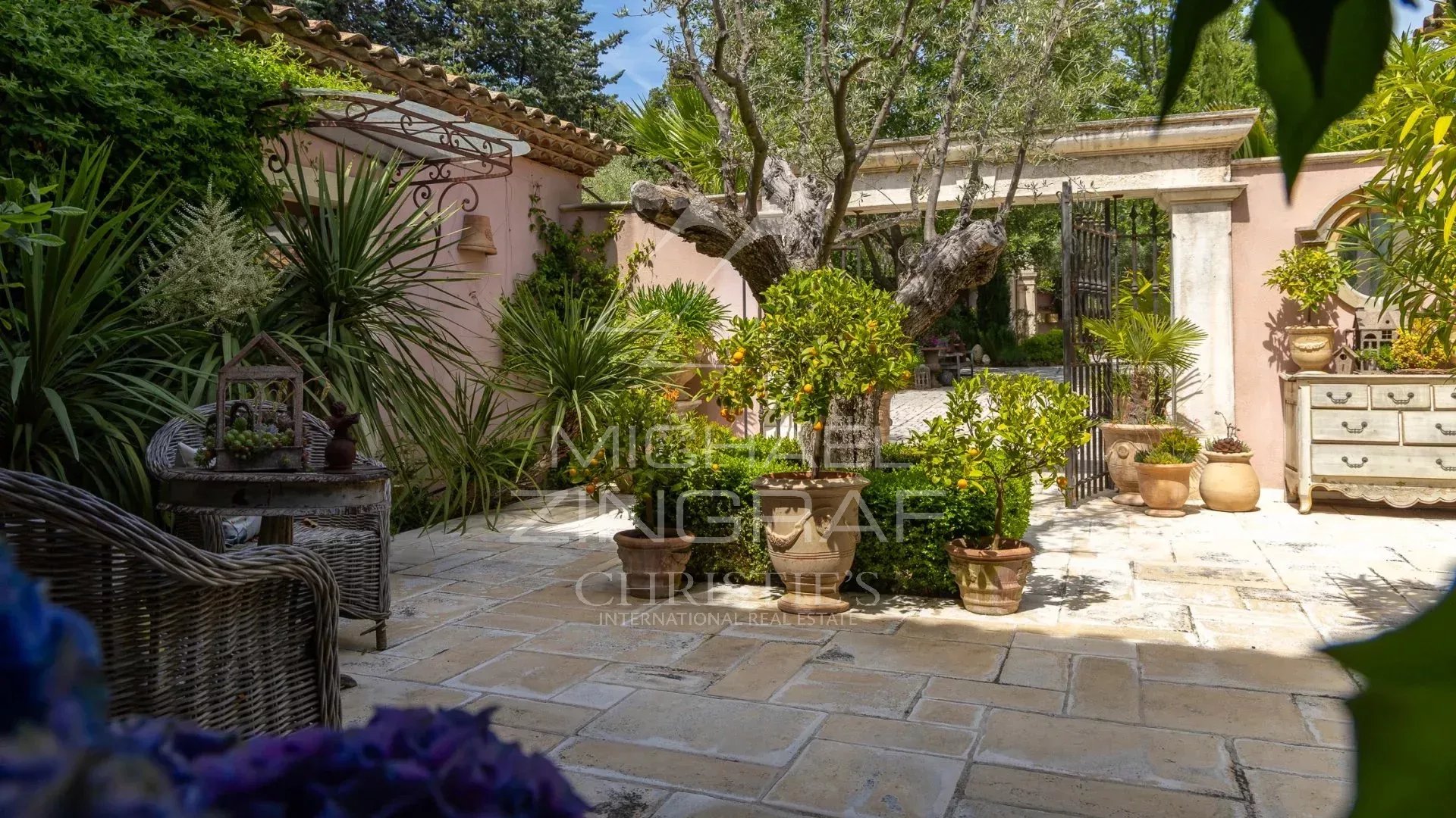 Garden of a charming estate in Draguignan with plants and a stone terrace.