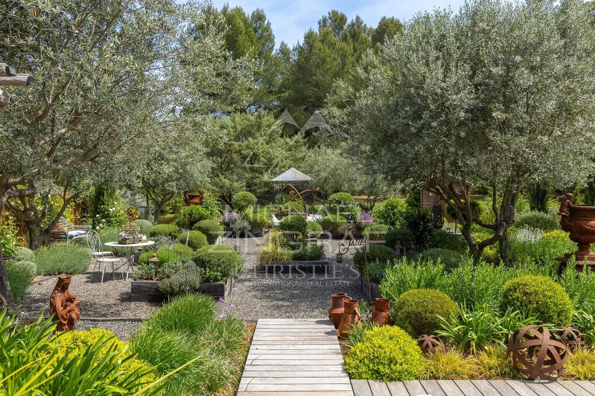 Garden of a charming estate in Draguignan with olive trees and relaxation areas.