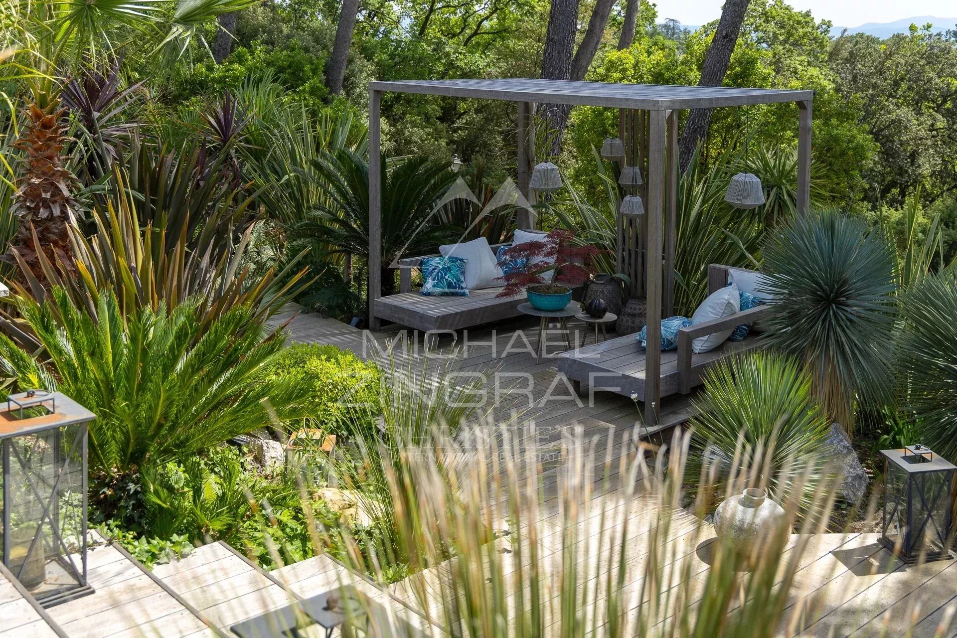 Outdoor space of a charming estate in Draguignan, with plants and a wooden seating area.