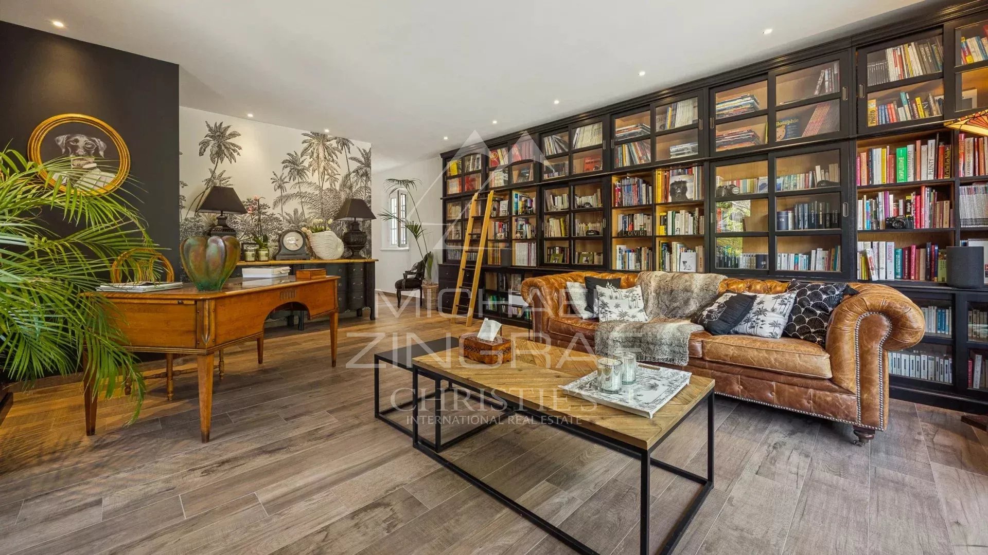 Interior of an elegant living room with library, leather sofa and refined decoration in an estate in Draguignan.