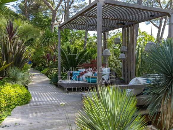 Outdoor space of a charming estate in Draguignan with exotic plants and a relaxation area.