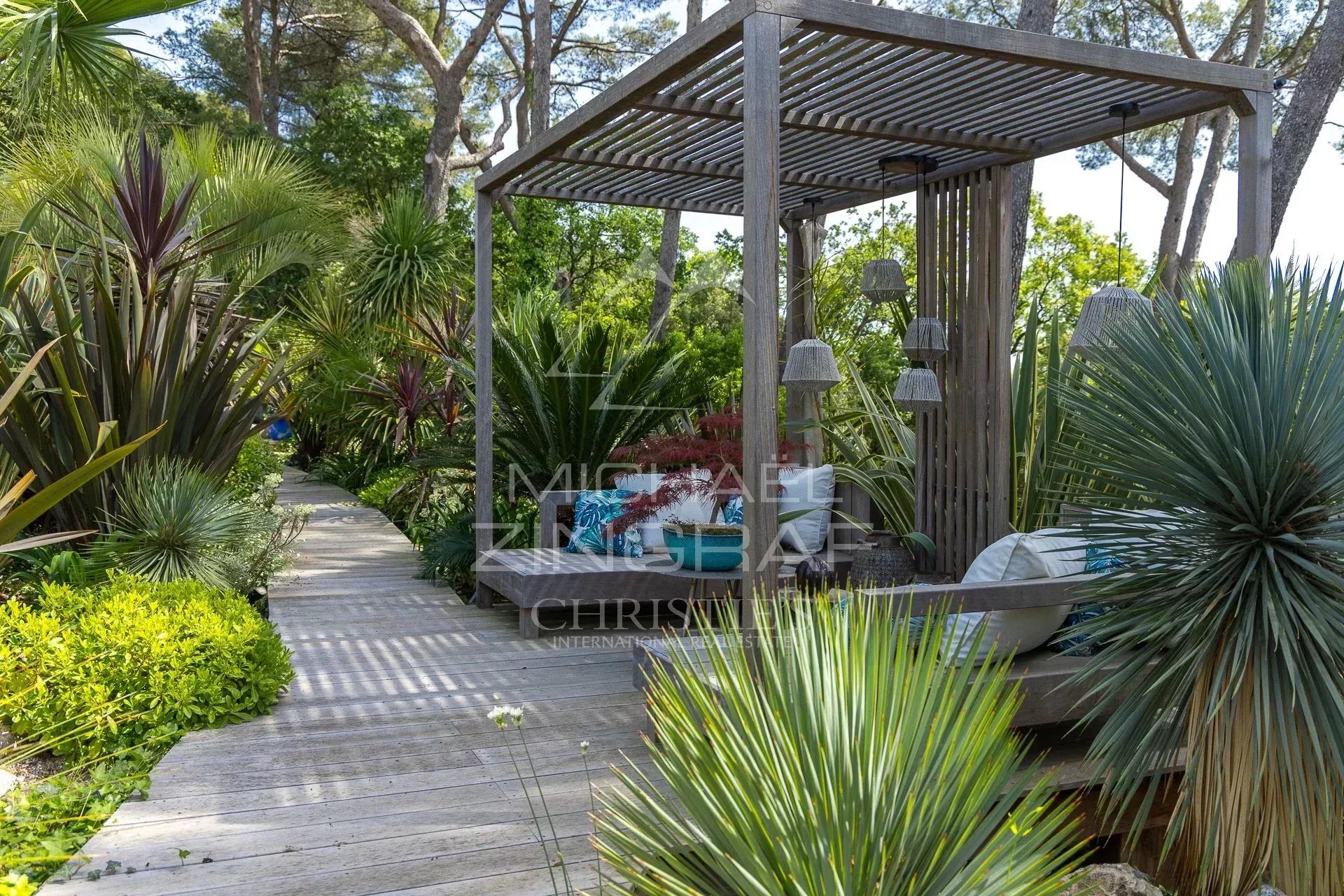 Outdoor space of a charming estate in Draguignan with exotic plants and a relaxation area.