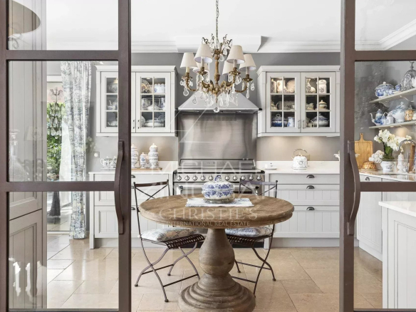 Elegant kitchen in a restored estate in Draguignan, with a round wooden table and refined tableware.