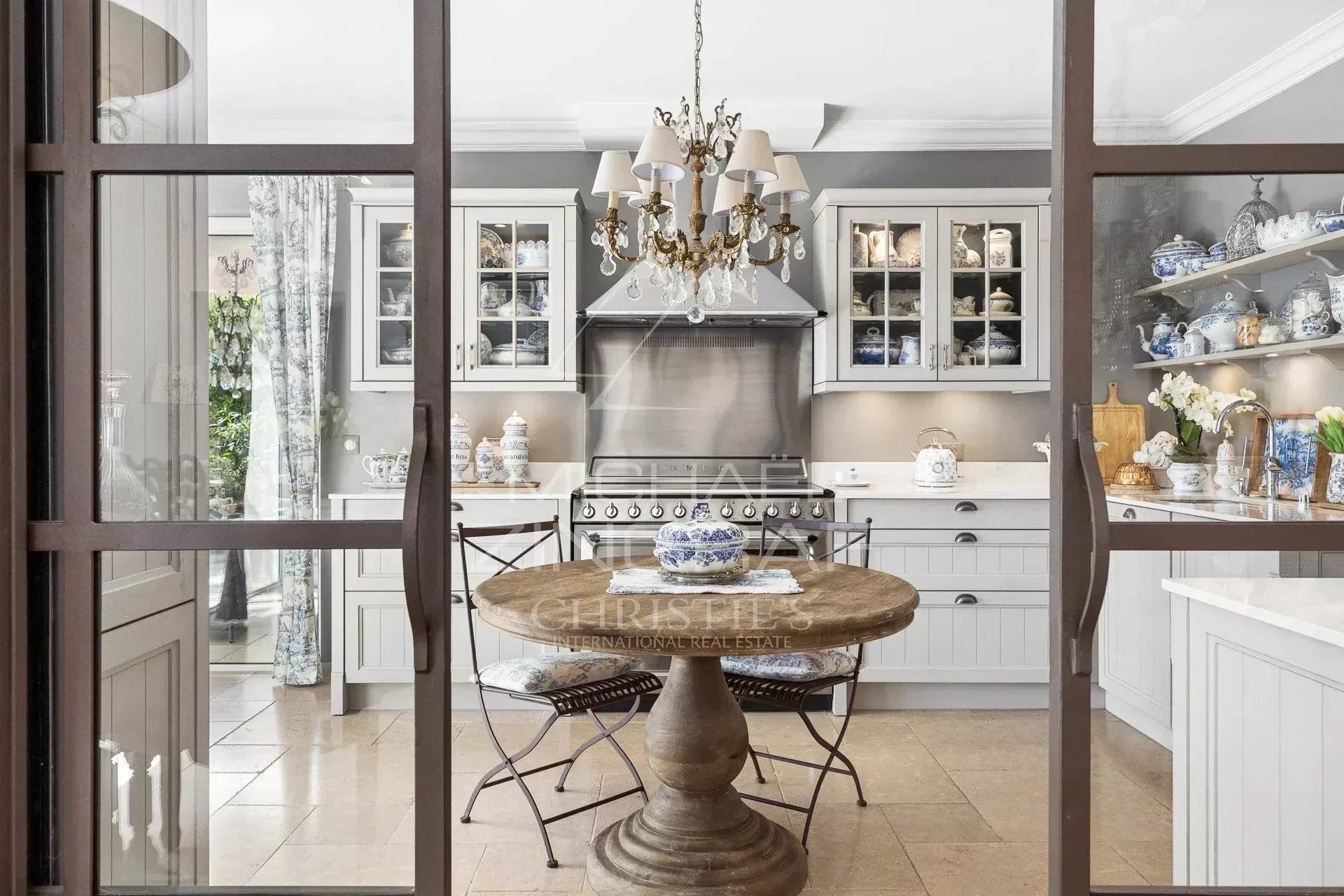Elegant kitchen in a restored estate in Draguignan, with a round wooden table and refined tableware.