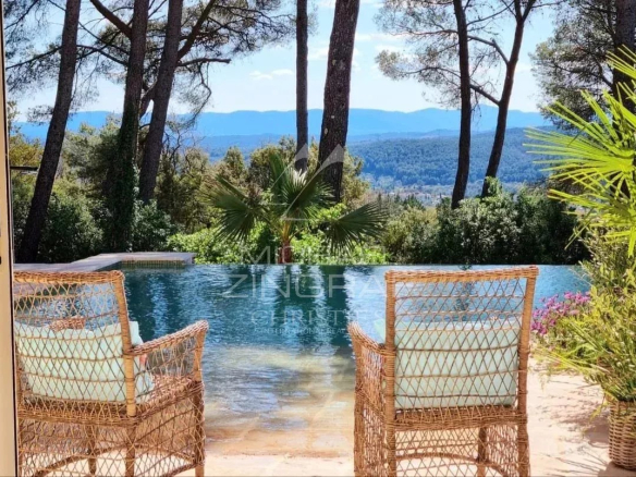 View of an estate with swimming pool and wicker chairs, surrounded by nature in Draguignan.