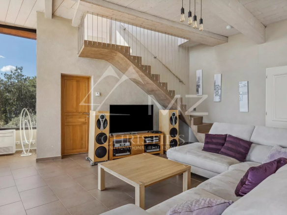 Interior of a villa in Fayence with a bright living room and wooden staircase.