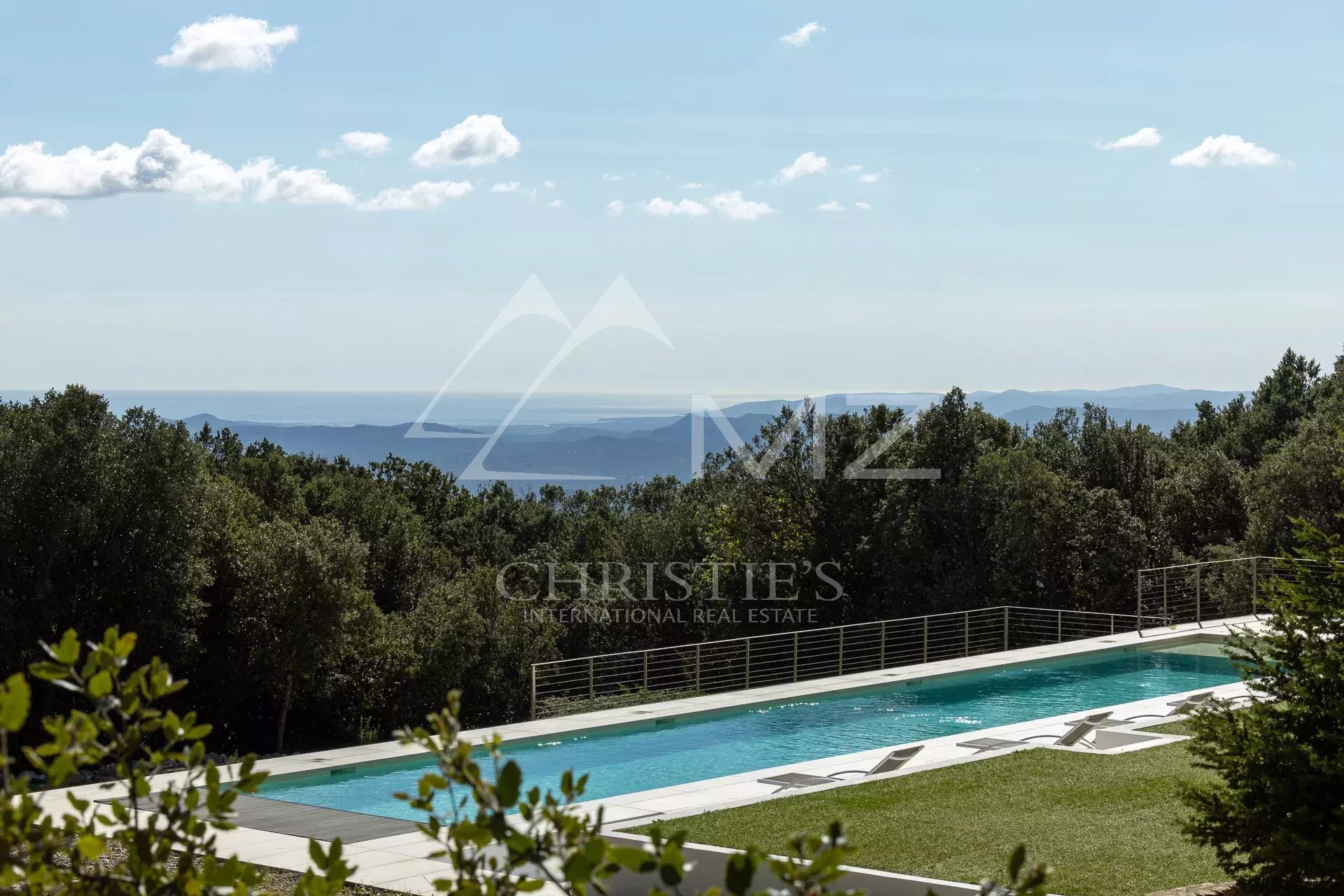Villa with swimming pool and sea view in Fayence, surrounded by greenery.