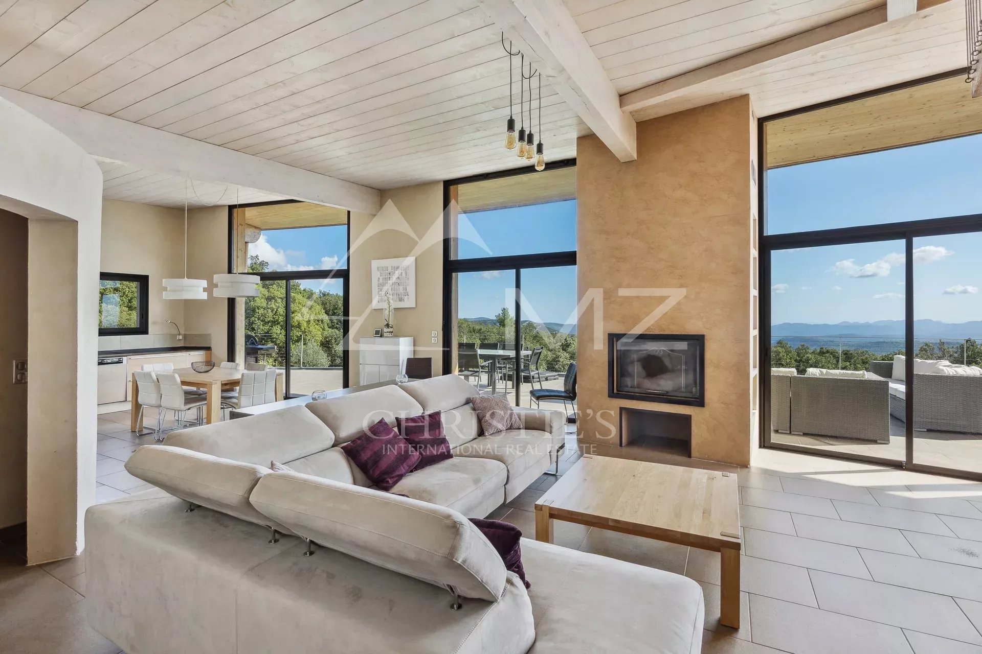 Interior of a modern property with panoramic views, bright living room and terrace in Fayence.