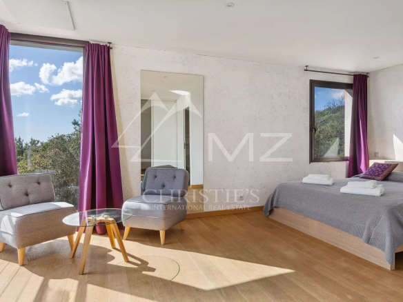 Bright room with panoramic views, armchairs and double bed in a property in Fayence.