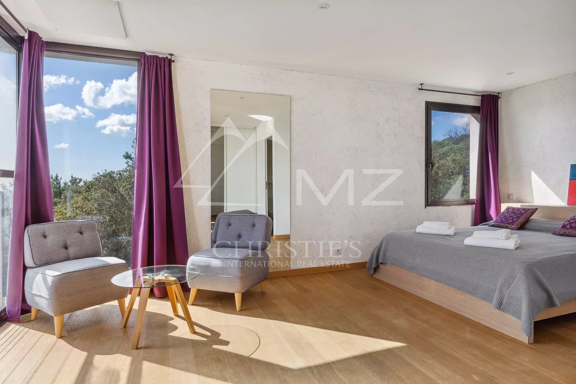 Bright room with panoramic views, armchairs and double bed in a property in Fayence.