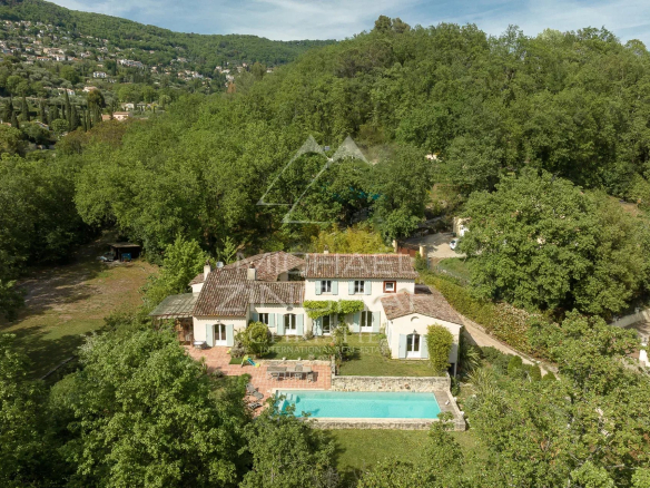 Vue aérienne d'une bastide moderne avec piscine entourée d'un parc arboré à Grasse.