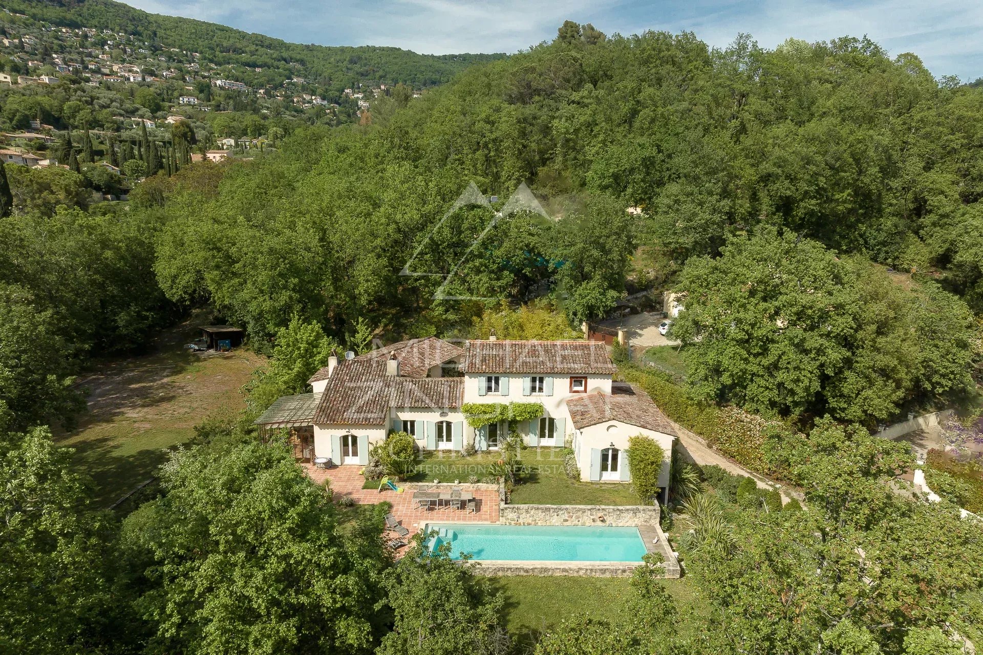 Bastide moderne à Grasse Vue aérienne d'une bastide moderne avec piscine entourée d'un parc arboré à Grasse.
