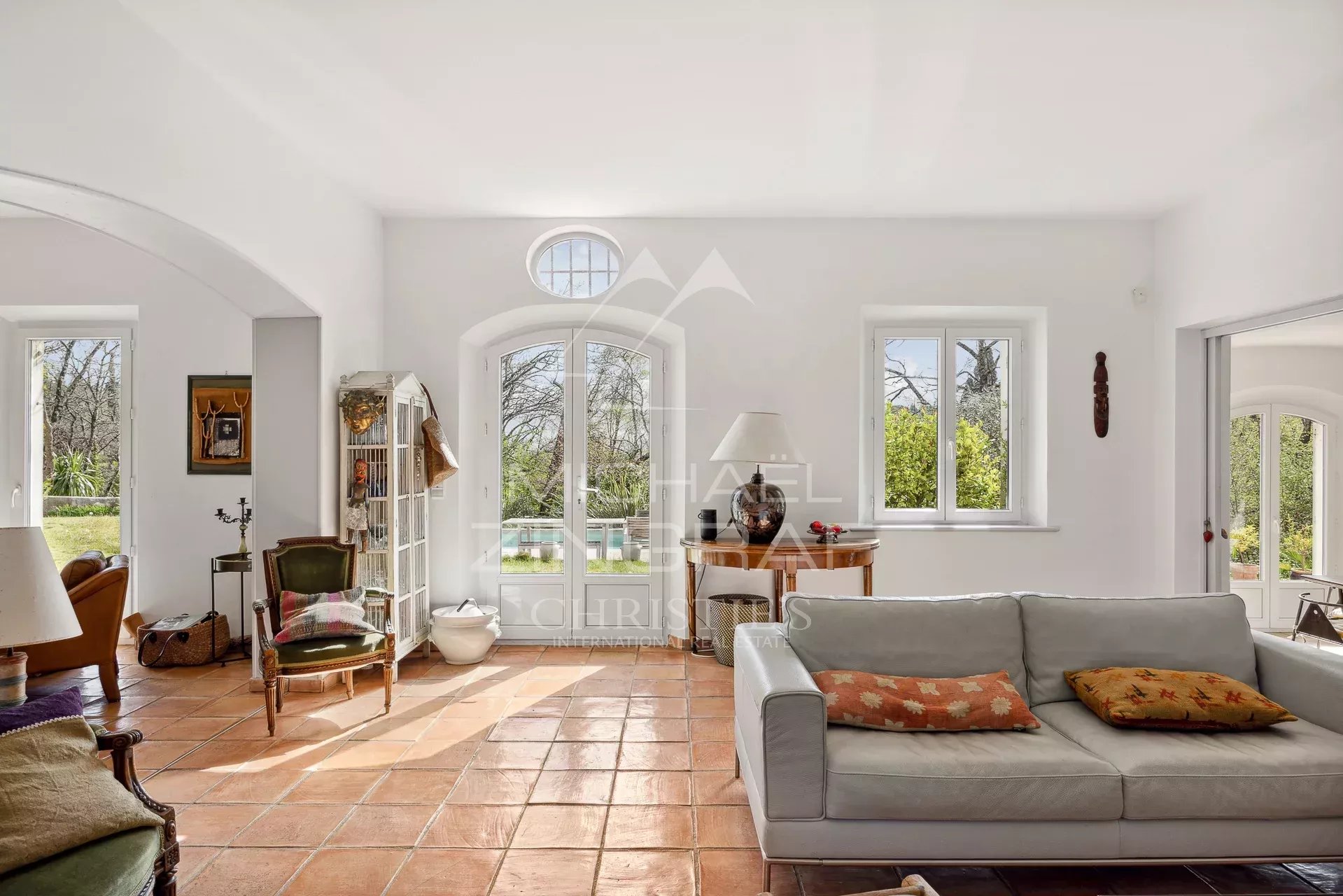 Intérieur d’une bastide à Grasse Intérieur lumineux d'une bastide moderne avec salon et grandes fenêtres donnant sur le parc.