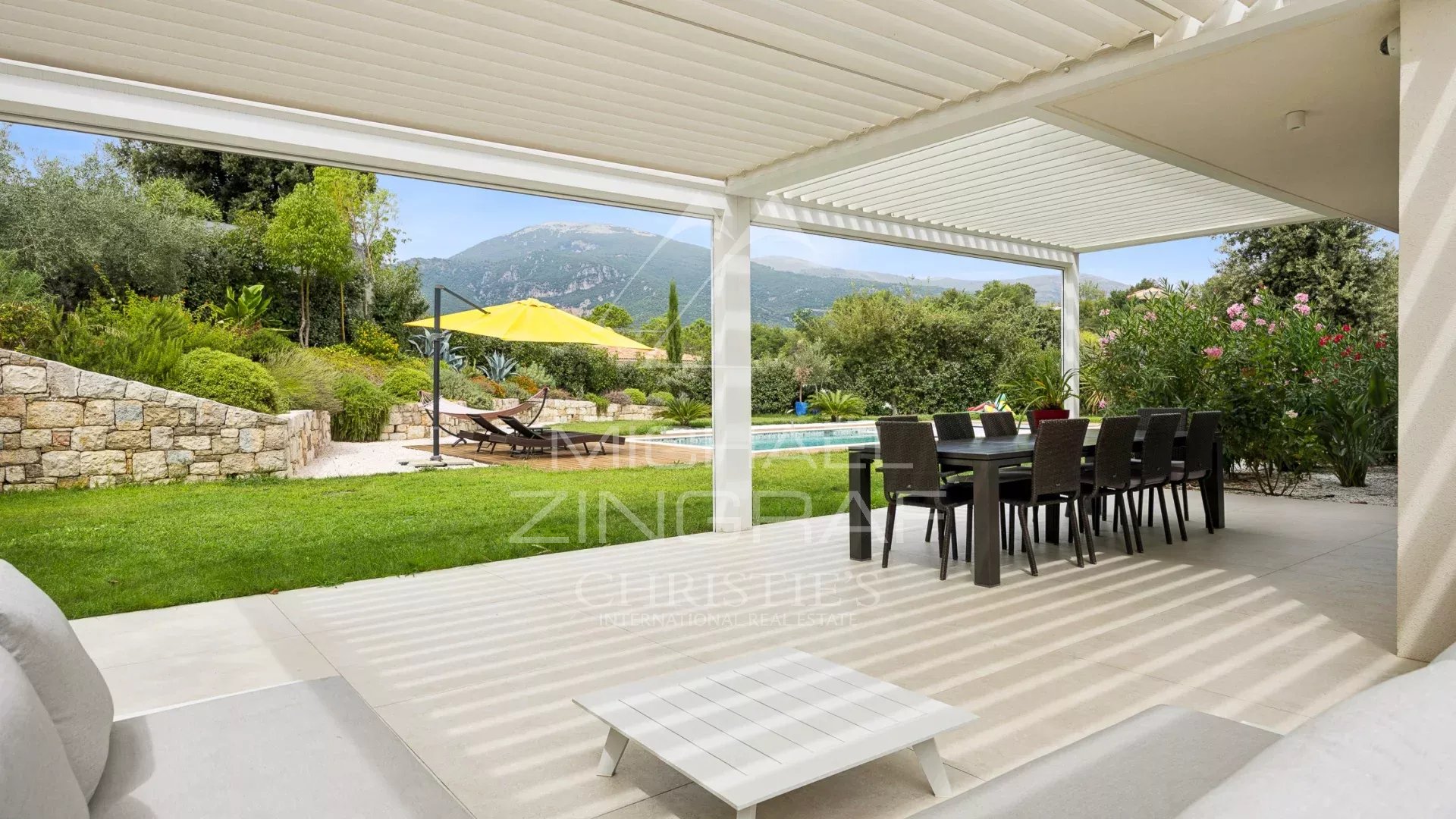 Villa contemporaine à Roquefort-les-Pins Terrasse d'une villa contemporaine avec mobilier de jardin et vue sur les collines à Roquefort-les-Pins.