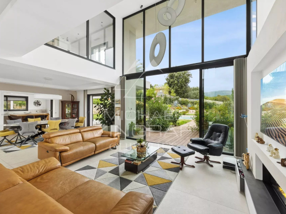 Intérieur d'une villa contemporaine à Roquefort-les-Pins avec salon, salle à manger et cuisine.