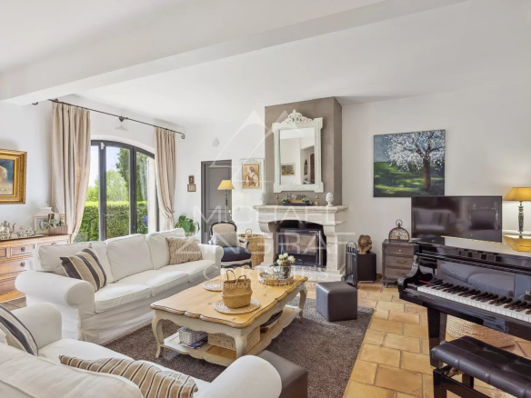 Interior of an elegant country house with a bright living room, piano and fireplace.