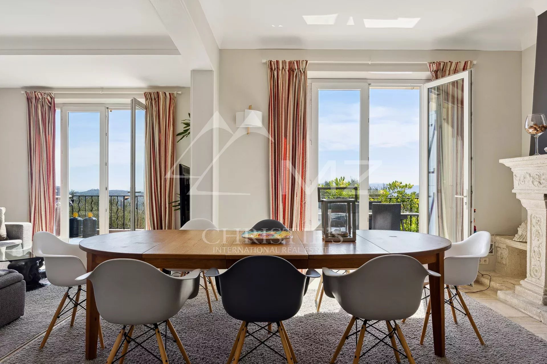 Interior of a villa in Châteauneuf-Grasse Interior of a villa in Châteauneuf-Grasse with a large dining table and windows opening onto the view.