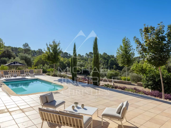 Terrasse ensoleillée avec piscine, chaises et vue sur la nature en Provence.