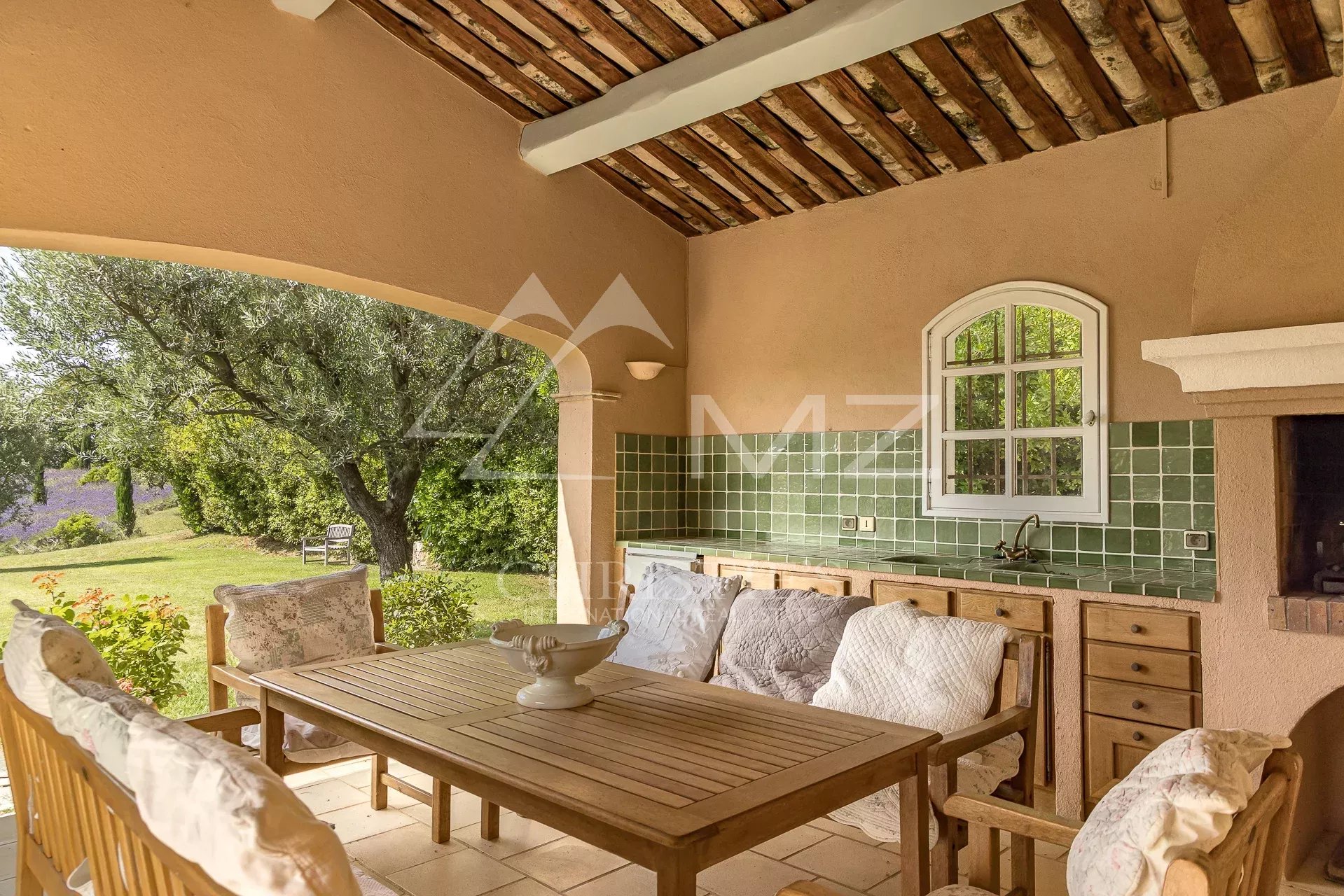 Terrasse d’une propriété provençale Terrasse d'une propriété à Saint-Vallier-de-Thiey avec mobilier en bois et cuisine extérieure.