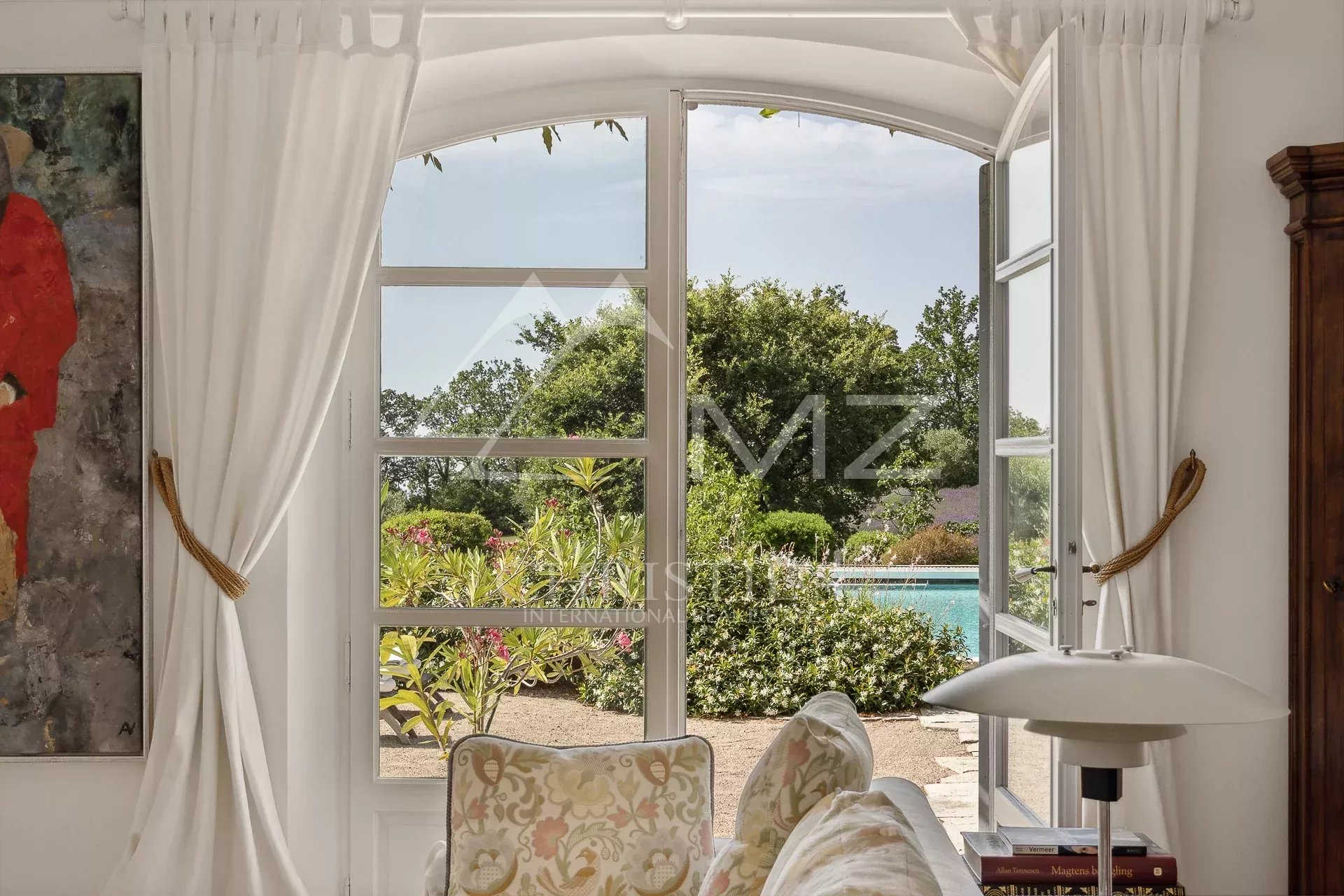 Propriété de charme à Saint-Vallier-de-Thiey Vue intérieure d'une maison avec fenêtres ouvertes sur un jardin et une piscine.