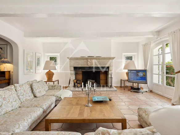 Intérieur d'une propriété avec un salon lumineux, cheminée et canapé confortable.