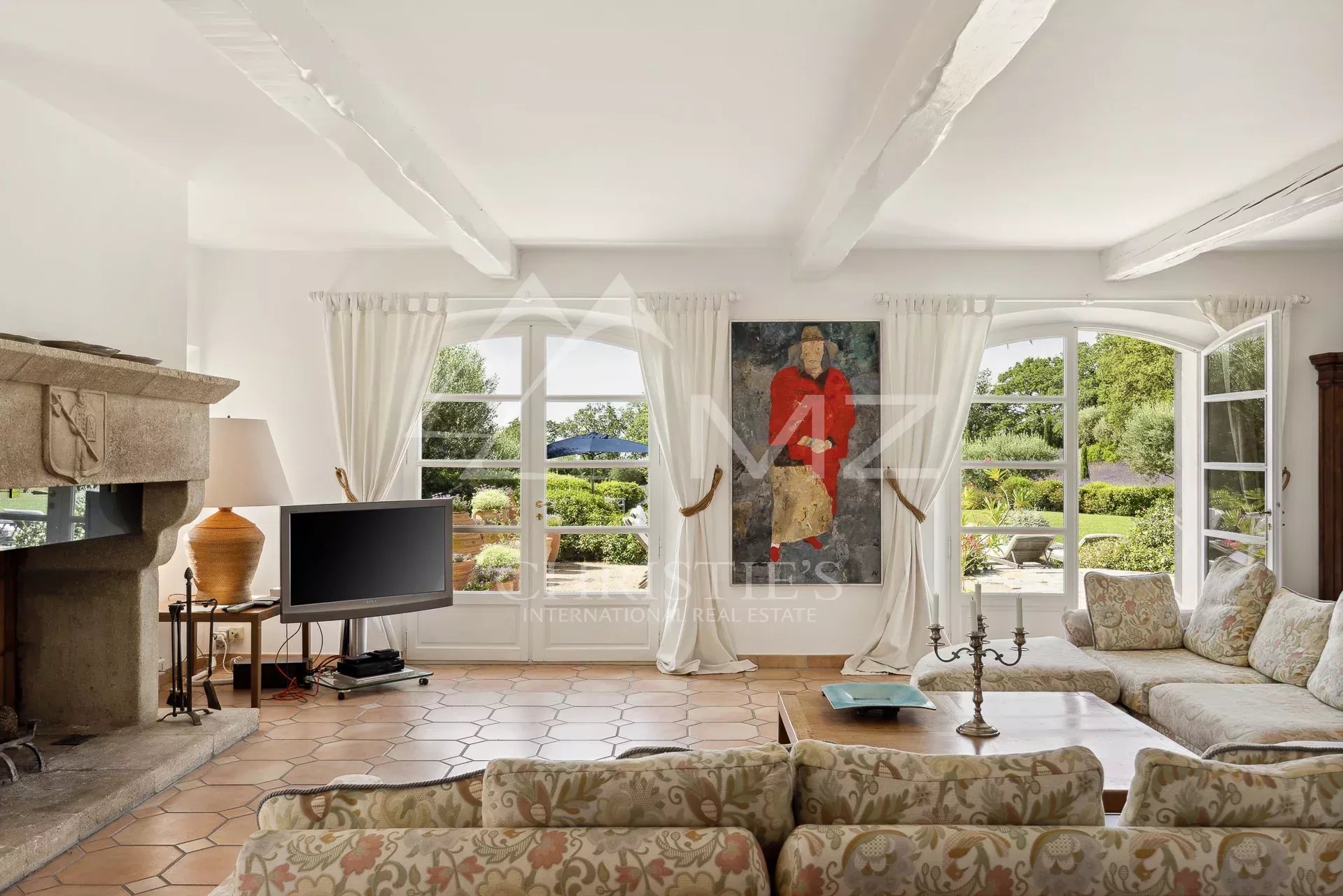 Salon lumineux d’une propriété provençale Intérieur d'une propriété avec salon lumineux, cheminée et vue sur le jardin.